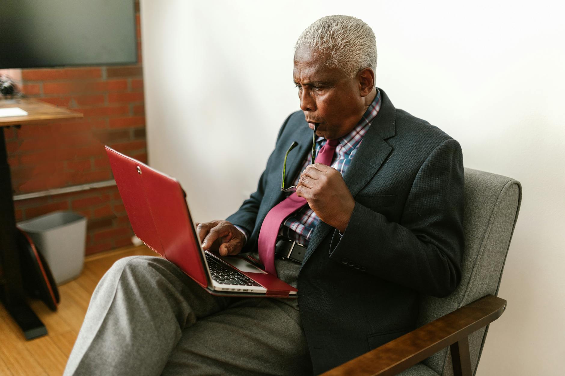 Professional male lead expert wearing glasses with thoughtful analytical approach